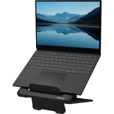 Hybrid worker using adjustable DeskStand Fellowes laptop stand to align screen at eye level.