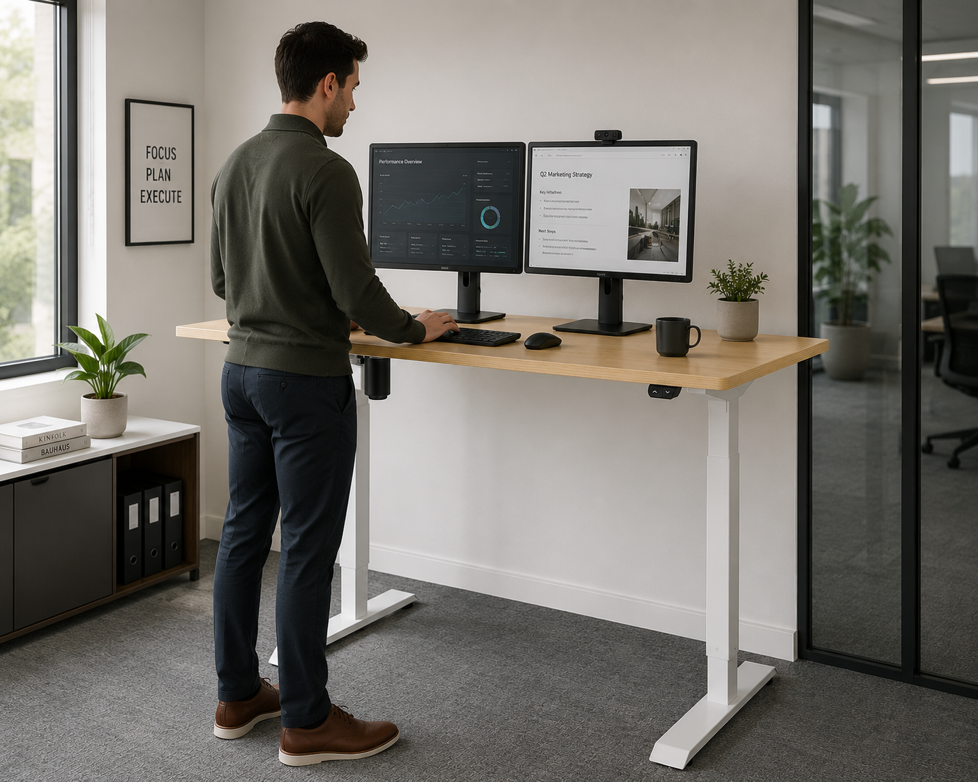 Person using a standing desk with two monitors in an office setting